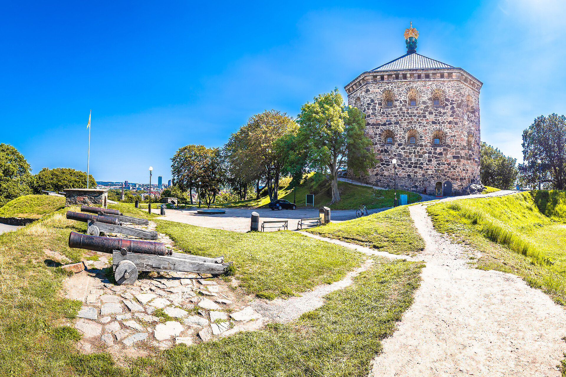 Ansicht der historischen Festung Skansen Kronan in Göteborg mit alten Kanonen im Vordergrund an einem sonnigen Tag.