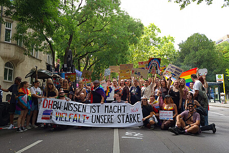 Gruppe beim CSD mit Regenbogenflaggen – ein Zeichen für Vielfalt und queere Sichtbarkeit.