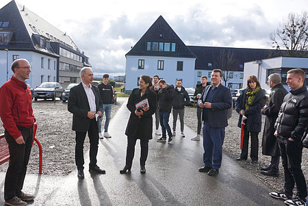 Personen stehen auf einem Hof