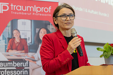 Prof. Dr. Martina Klärle an einem Rednerpult mit Mikrofon in der Hand