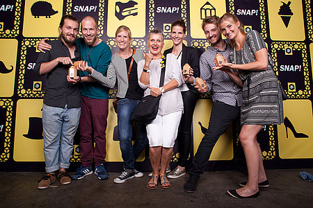 6 Studierende aus dem Bereich Mediendesign stehen mit ihrer Betreuerin auf einer Bühne und freuen sich über die Auszeichnung bei der Preisverleihung des red dot: best of the best in London. 