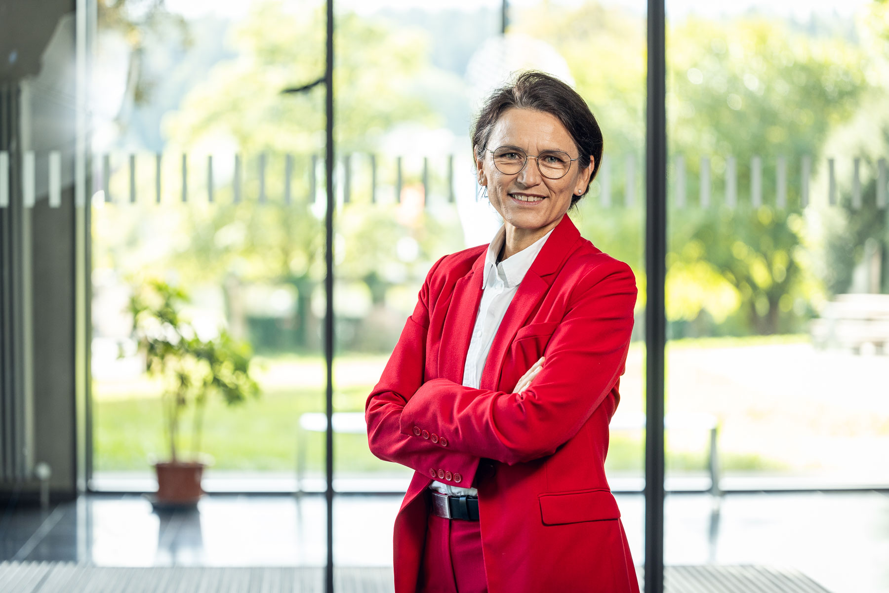Martina Klärle in rotem Hosenanzug und mit verschränkten Armen